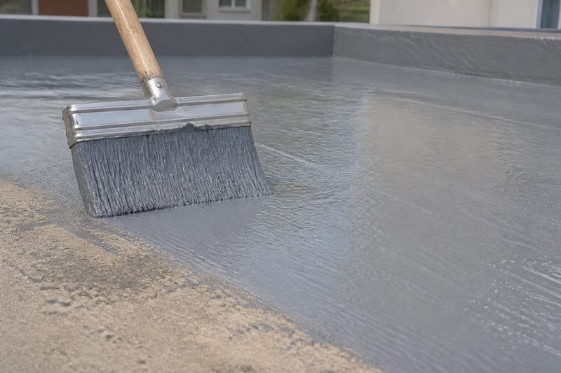 Brush applying waterproofing coating
